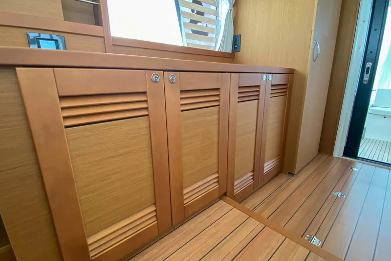 Toot 2 Yacht Photos Pics Interior view of 2023 Beneteau Swift Trawler 41 Fly, featuring wooden cabinetry and flooring.