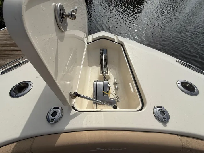  Yacht Photos Pics Open storage compartment on 2020 Scout 277 LXF boat, docked by the water.