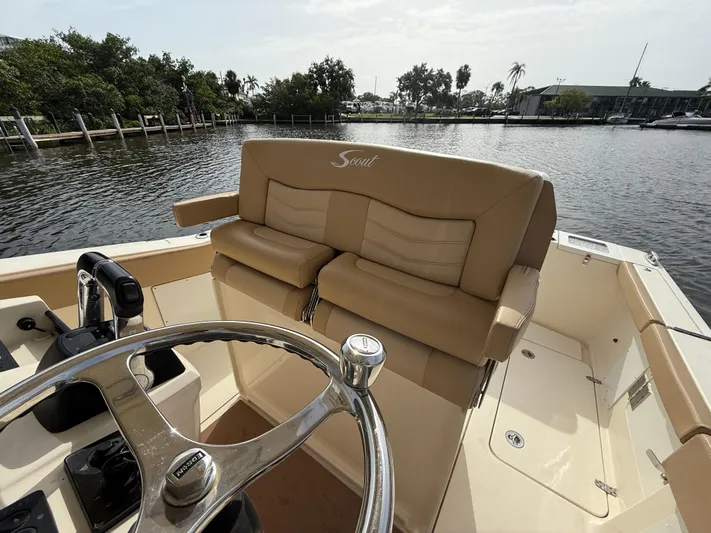  Yacht Photos Pics 2020 Scout 277 LXF boat interior with tan seating and steering wheel, dockside view.