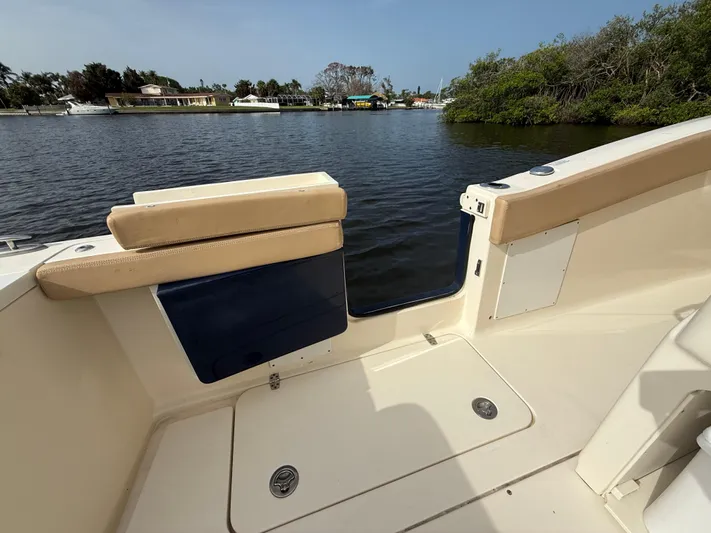  Yacht Photos Pics 2020 Scout 277 LXF boat interior with water view, featuring beige seating and storage compartments.