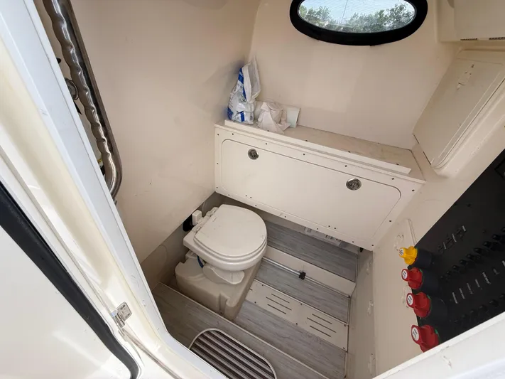  Yacht Photos Pics 2020 Scout 277 LXF boat interior with compact bathroom and toilet.