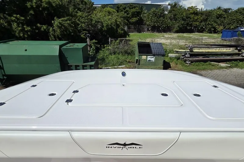 Hit N Run Yacht Photos Pics 2020 Invincible 35 Catamaran deck view with storage compartments, surrounded by greenery.