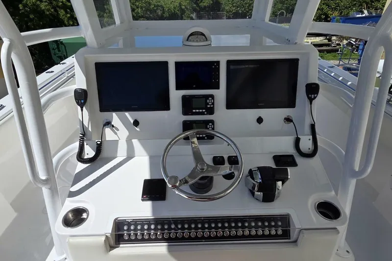 Hit N Run Yacht Photos Pics 2020 Invincible 35 Catamaran helm with dual screens, steering wheel, and controls.