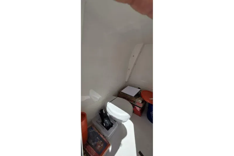 Hit N Run Yacht Photos Pics Interior of 2020 Invincible 35 Catamaran showing storage area with toilet and supplies.