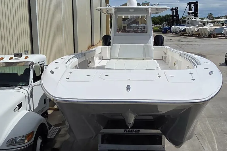 Hit N Run Yacht Photos Pics 2020 Invincible 35 Catamaran on trailer, parked beside a truck in a marina.