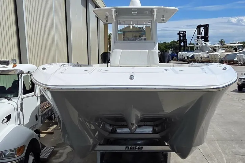 Hit N Run Yacht Photos Pics 2020 Invincible 35 Catamaran on trailer, parked outdoors near industrial buildings.