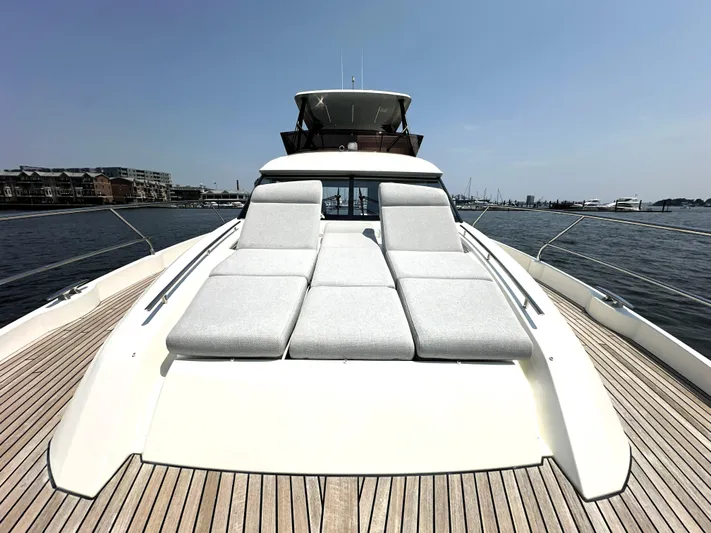 Perpetually Investing Yacht Photos Pics 2022 Prestige 520 yacht with sun loungers on deck, docked in a marina.