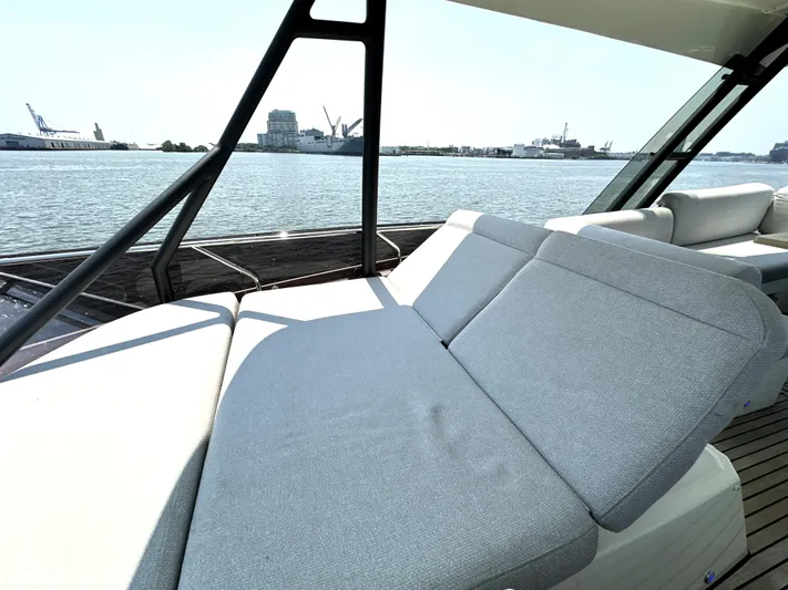 Perpetually Investing Yacht Photos Pics Luxurious 2022 Prestige 520 yacht with spacious sunbathing area, overlooking serene waterfront.