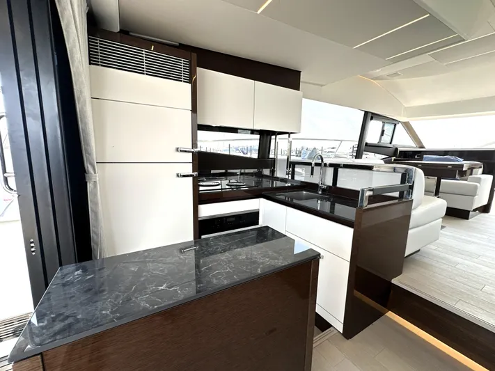 Perpetually Investing Yacht Photos Pics Luxurious interior of 2022 Prestige 520 yacht with modern kitchen and seating area.