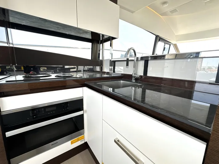 Perpetually Investing Yacht Photos Pics Modern kitchen interior on 2022 Prestige 520 yacht with sleek countertops and appliances.