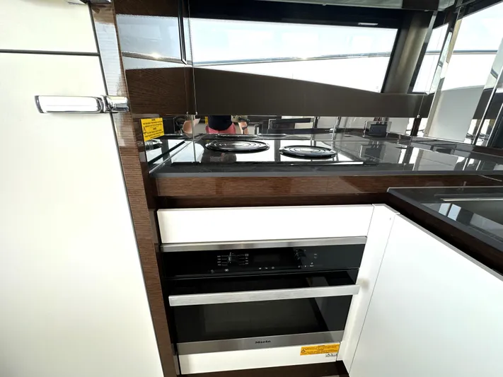 Perpetually Investing Yacht Photos Pics Modern kitchen in 2022 Prestige 520 yacht with sleek appliances and glossy finishes.