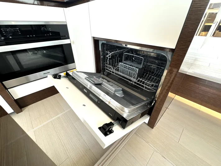 Perpetually Investing Yacht Photos Pics Modern kitchen with open dishwasher in a 2022 Prestige 520 yacht.