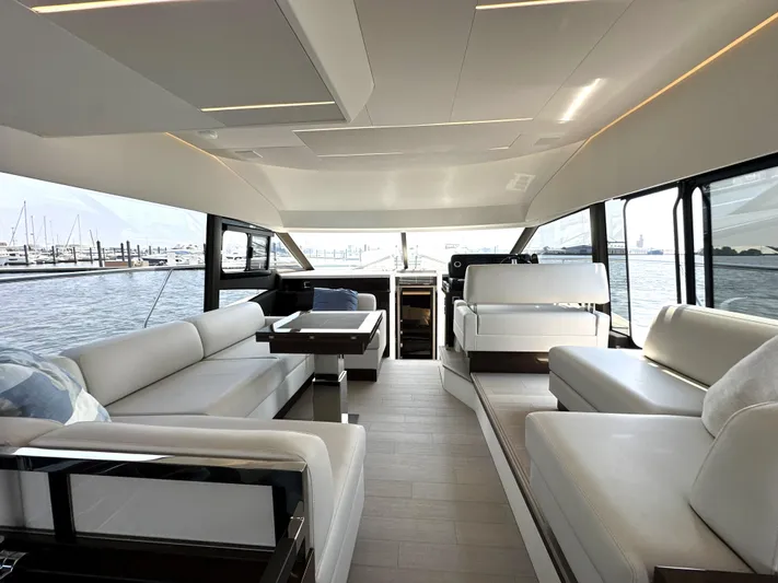 Perpetually Investing Yacht Photos Pics Luxurious interior of a 2022 Prestige 520 yacht with elegant seating and panoramic windows.