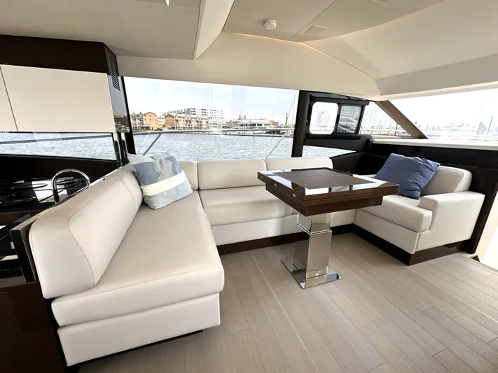 Perpetually Investing Yacht Photos Pics Luxurious interior of 2022 Prestige 520 yacht with elegant seating and waterfront view.