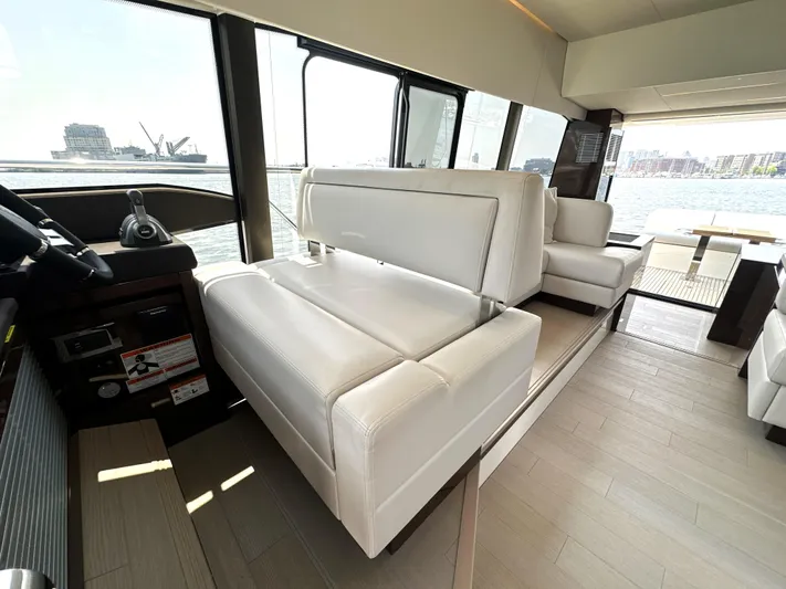 Perpetually Investing Yacht Photos Pics Luxurious interior of 2022 Prestige 520 yacht with white leather seating and panoramic windows.
