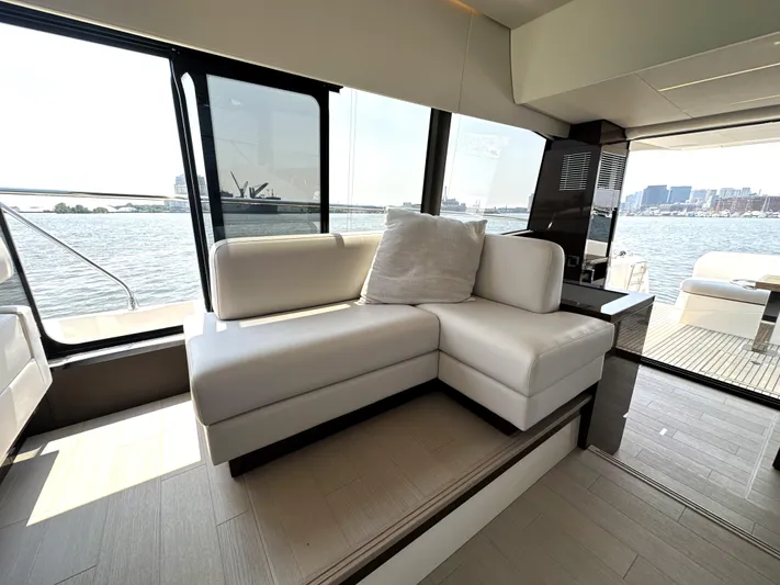 Perpetually Investing Yacht Photos Pics Luxurious interior of 2022 Prestige 520 yacht with white seating and waterfront view.