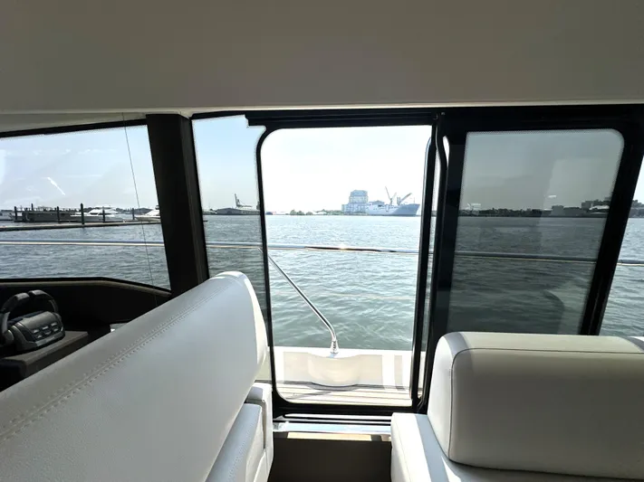 Perpetually Investing Yacht Photos Pics Interior view from a 2022 Prestige 520 yacht, overlooking a serene waterfront.