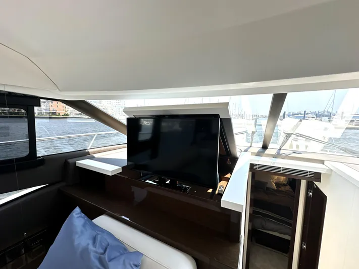 Perpetually Investing Yacht Photos Pics Luxurious interior of 2022 Prestige 520 yacht with retractable TV and waterfront view.