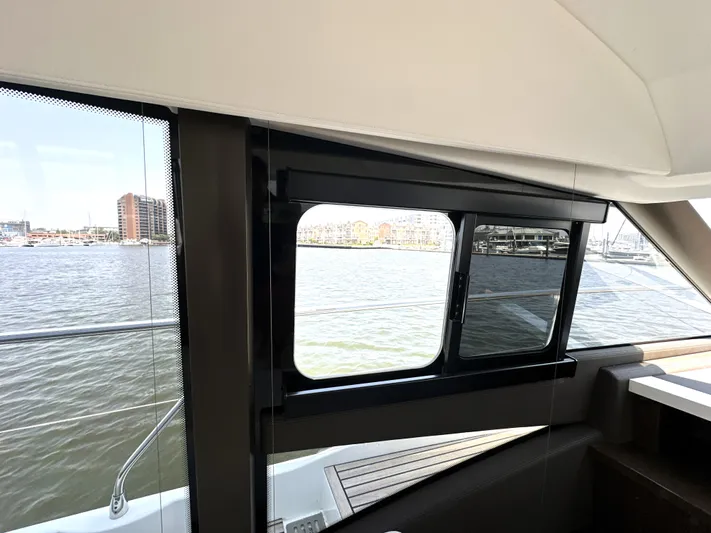 Perpetually Investing Yacht Photos Pics Interior view from a 2022 Prestige 520 yacht, showcasing water and cityscape through windows.