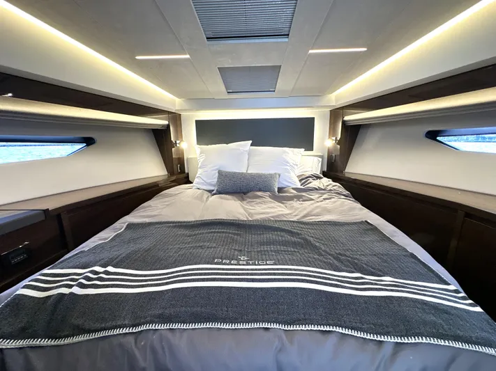 Perpetually Investing Yacht Photos Pics Luxurious bedroom interior of 2022 Prestige 520 yacht with elegant bedding and ambient lighting.