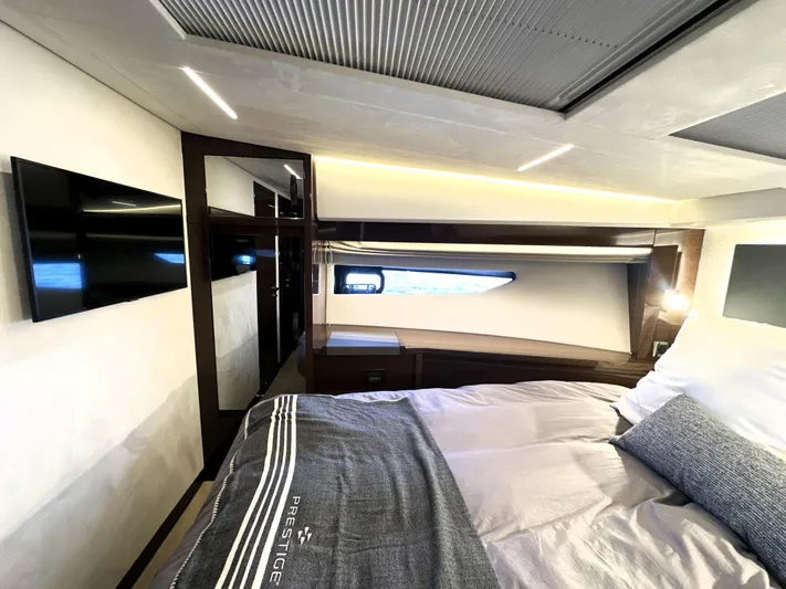 Perpetually Investing Yacht Photos Pics Luxurious bedroom interior of 2022 Prestige 520 yacht with modern design and cozy bedding.
