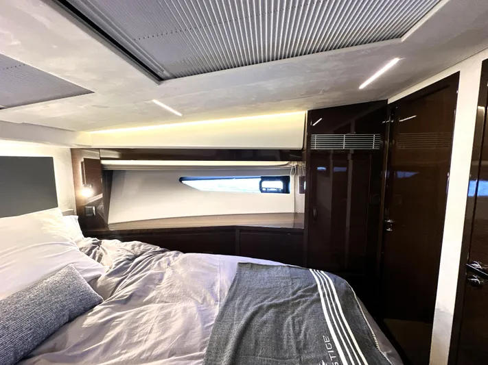 Perpetually Investing Yacht Photos Pics Luxurious interior of 2022 Prestige 520 yacht bedroom with modern design and cozy bedding.