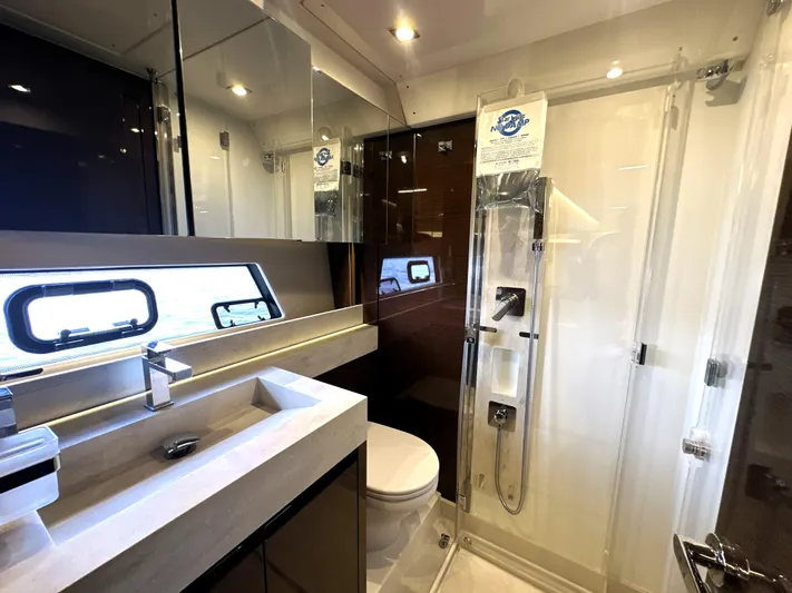 Perpetually Investing Yacht Photos Pics Luxurious bathroom in 2022 Prestige 520 yacht with modern fixtures and glass shower.