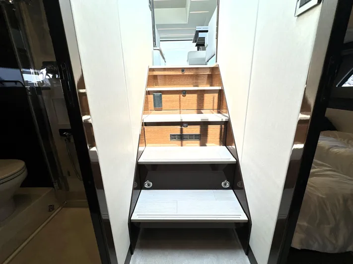 Perpetually Investing Yacht Photos Pics Staircase inside 2022 Prestige 520 yacht, leading to upper deck, modern interior design.