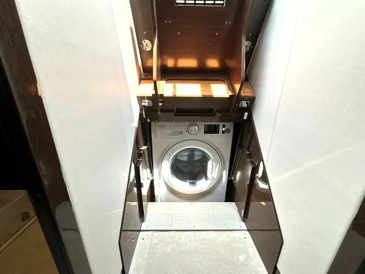 Perpetually Investing Yacht Photos Pics Laundry area with a washing machine inside a 2022 Prestige 520 yacht.