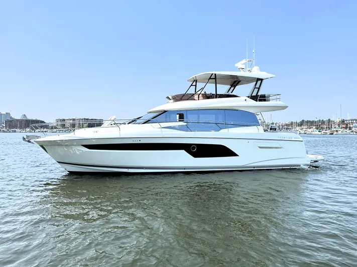 Perpetually Investing Yacht Photos Pics Luxury 2022 Prestige 520 yacht on calm water, showcasing sleek design and modern features.