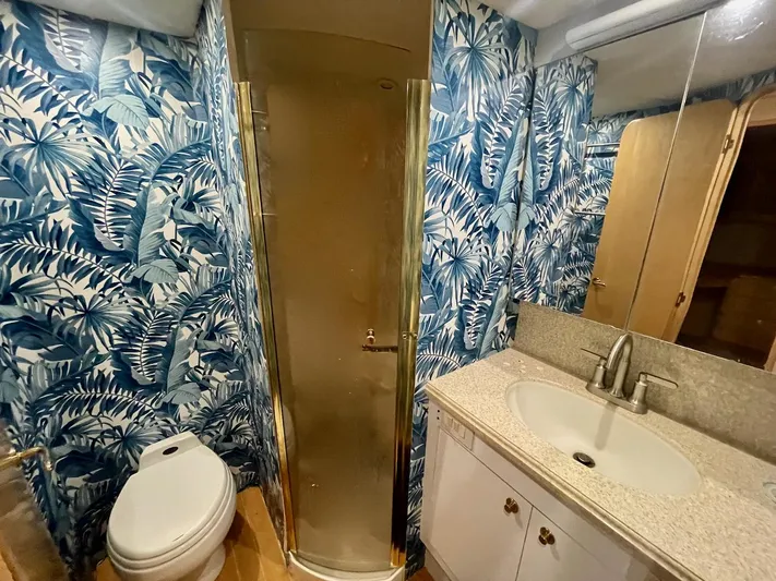 Snow Bank Yacht Photos Pics Luxurious bathroom in 2003 Ocean Yachts 62 Enclosed Bridge with tropical wallpaper and modern fixtures.