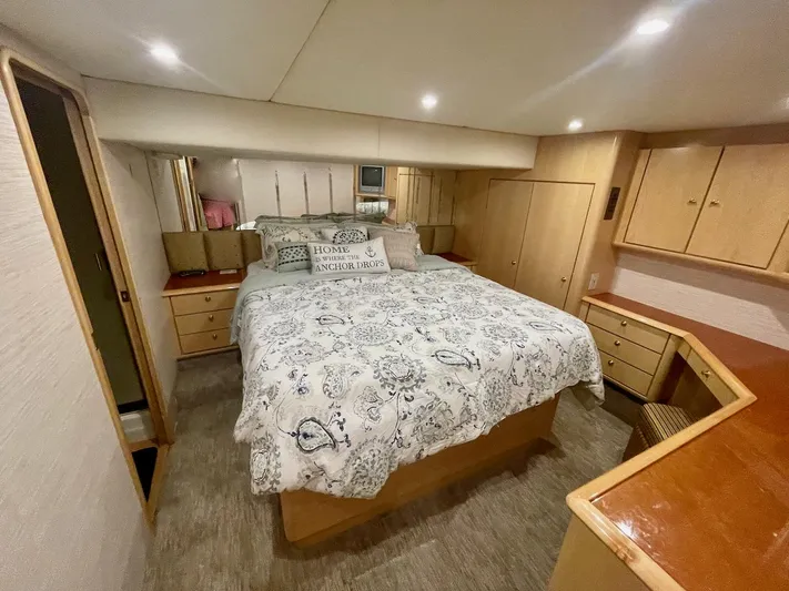 Snow Bank Yacht Photos Pics Luxurious bedroom in 2003 Ocean Yachts 62 Enclosed Bridge, featuring elegant wood cabinetry.