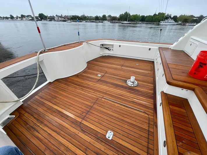 Snow Bank Yacht Photos Pics 2003 Ocean Yachts 62 Enclosed Bridge with polished wooden deck, docked by a calm waterfront.