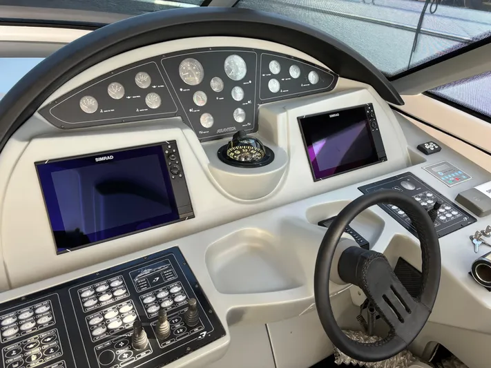  Yacht Photos Pics Control panel of a 2005 Baia Atlantica 78 yacht with navigation screens and steering wheel.