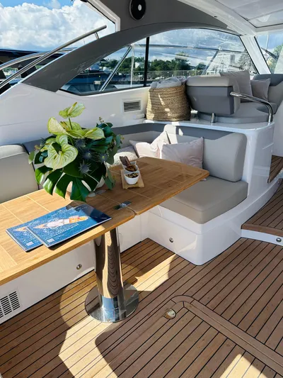 Rascal Yacht Photos Pics Luxurious 2024 Princess V40 yacht interior with elegant seating and wooden table.