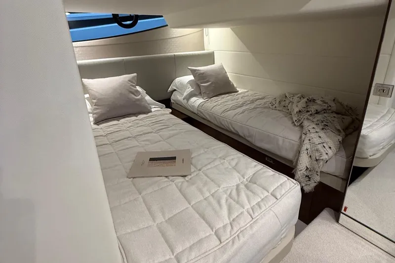 Rascal Yacht Photos Pics Luxurious 2024 Princess V40 yacht cabin with twin beds and elegant decor.