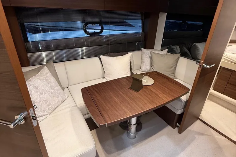 Rascal Yacht Photos Pics Luxurious interior of 2024 Princess V40 yacht with elegant seating and wooden table.