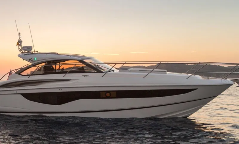 Rascal Yacht Photos Pics 2024 Princess V40 yacht cruising at sunset on calm waters.