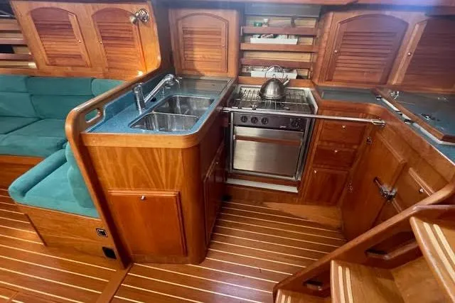 White Rose Yacht Photos Pics Luxurious 2003 Sabre 426 yacht interior with wooden cabinetry and modern kitchen amenities.