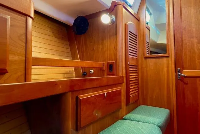 White Rose Yacht Photos Pics Interior of 2004 Sabre 426 sailboat with wooden cabinetry and green cushioned seating.