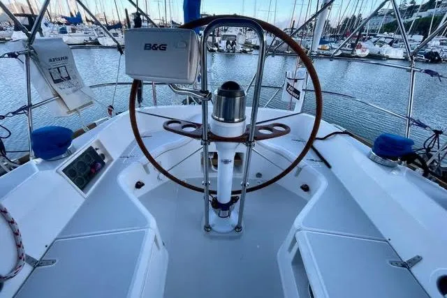 White Rose Yacht Photos Pics 2004 Sabre 426 yacht cockpit with steering wheel, navigation equipment, and marina view.