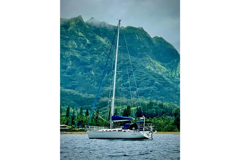 White Rose Yacht Photos Pics Sailboat Sabre 426 (2004) anchored near lush green mountains.