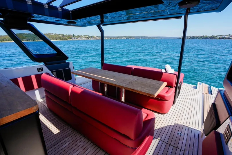  Yacht Photos Pics Luxurious 2025 Cranchi A46 Tender with red seating, wooden table, and scenic ocean view.