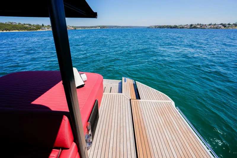  Yacht Photos Pics 2025 Cranchi A46 Luxury Tender with red seating, overlooking serene blue waters.