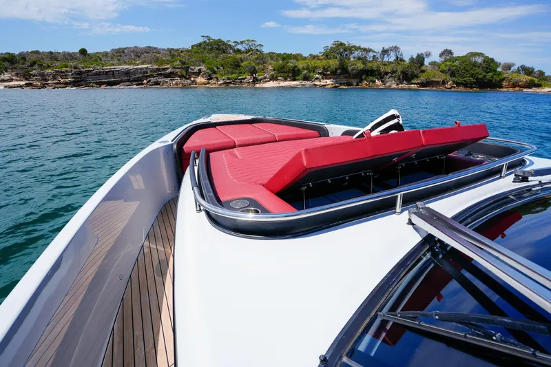  Yacht Photos Pics 2025 Cranchi A46 Luxury Tender with red seating, cruising near a scenic coastline.