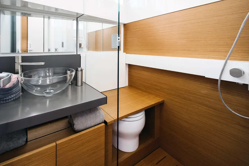 Bluegame 62 Yacht Photos Pics Modern bathroom on 2019 Bluegame BG62 yacht with glass sink and wooden accents.