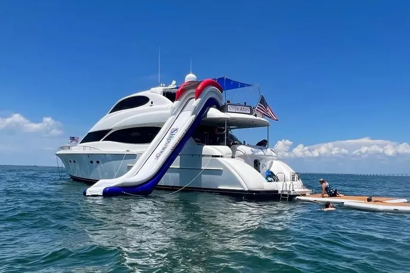  Yacht Photos Pics 2004 Lazzara SC Motor Yacht with slide, anchored in clear blue waters.