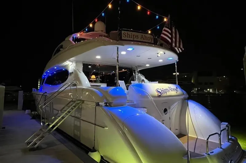  Yacht Photos Pics 2004 Lazzara SC Motor Yacht at night, illuminated with colorful lights and American flag.