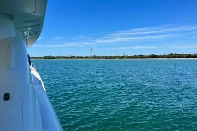  Yacht Photos Pics 2004 Lazzara SC Motor Yacht cruising on serene blue waters under clear skies.
