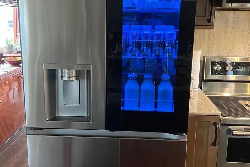  Yacht Photos Pics Modern kitchen with stainless steel refrigerator featuring a blue-lit display, aboard a 2004 Lazzara SC Motor Yacht.